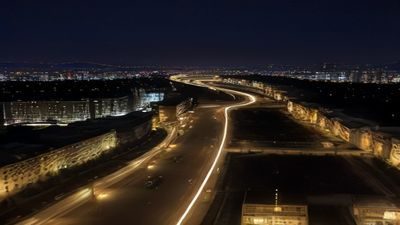 韩国都市夜景中警车追逐场面，霓虹灯光反射在湿润街道上，画面冷峻紧张